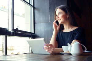 woman talking on phone and using tablet in a luxury rehab center in california