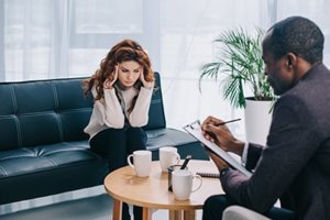 female patient helped by treatment professional during bipolar disorder treatment program