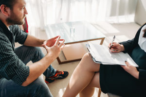 male patient talks to female counselor in ambien addiction treatment