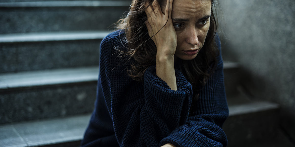 symptoms of alcohol abuse woman sits on stairs outside experiencing symptoms of alcohol abuse