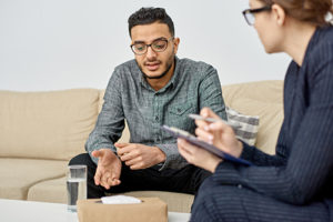 male patient sits on couch talking to female counselor about the vivitrol shot